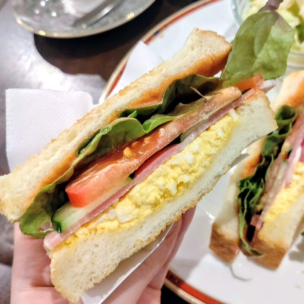 黒カフェの具沢山のサンドイッチ