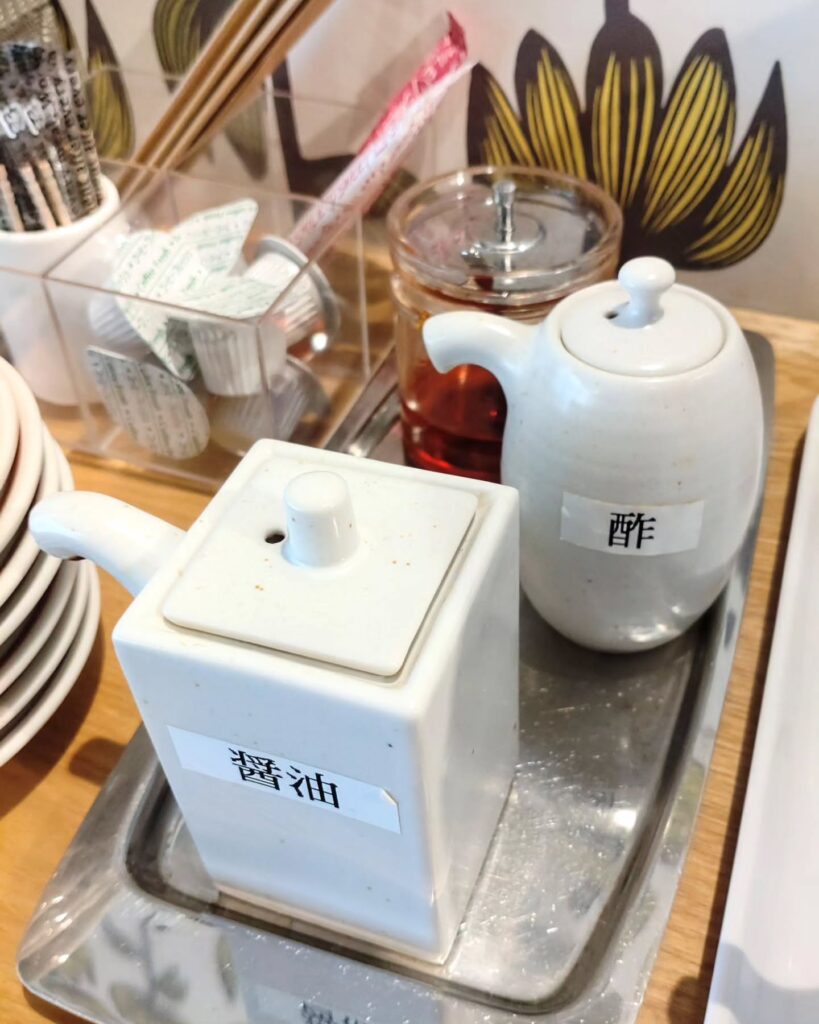 富小路粥店の卓上の酢と醤油